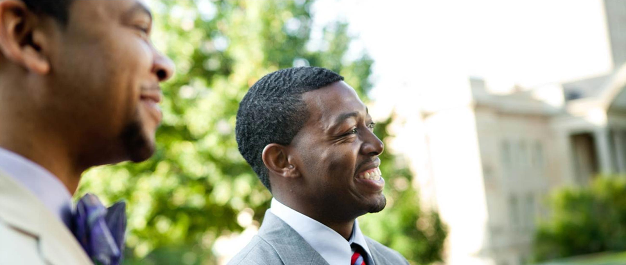 Two young men talking and laughing as they stand outside